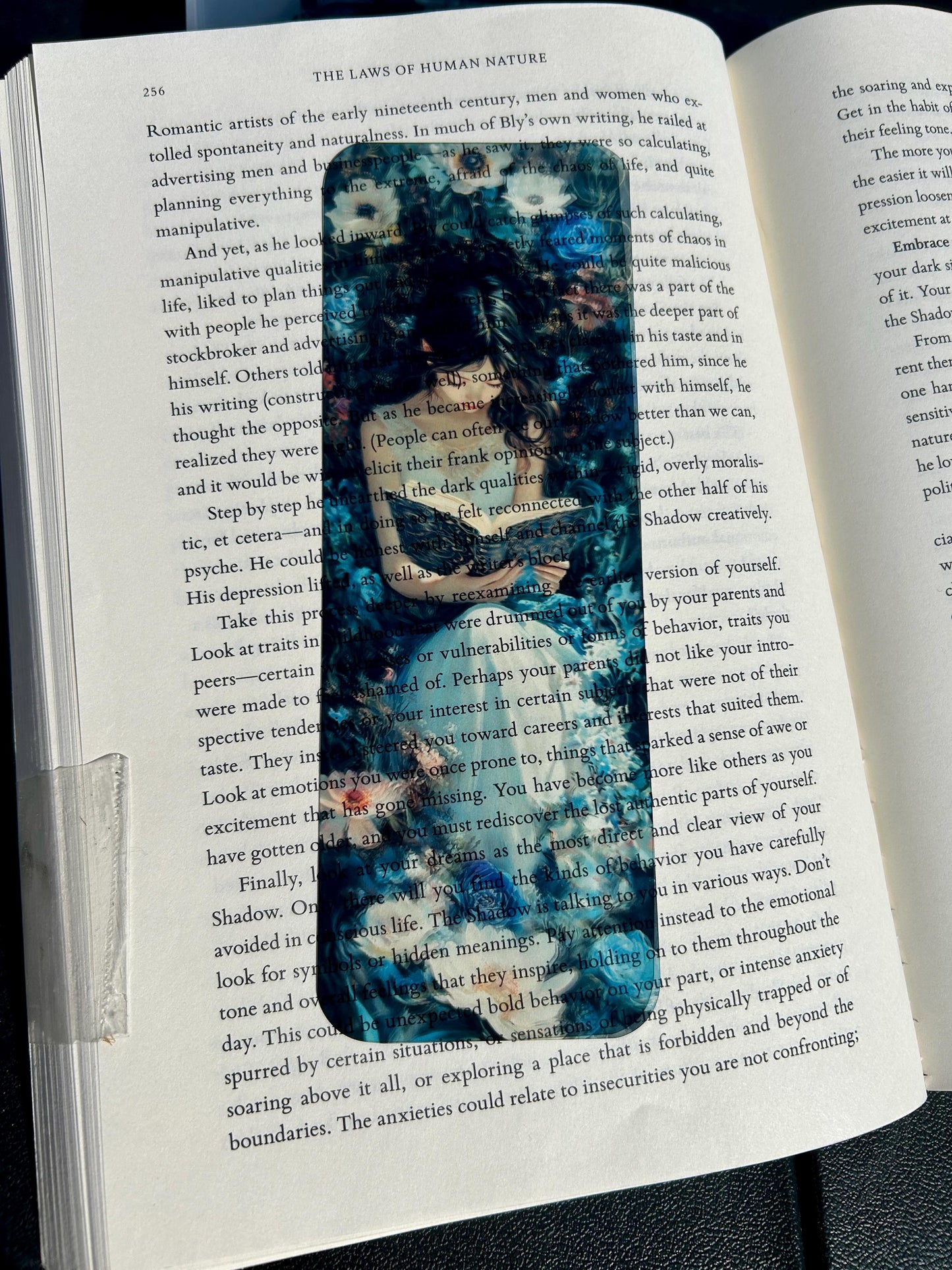 Floral fantasy bookmark with girl reading in white dress, surrounded by lush blue and white blossoms