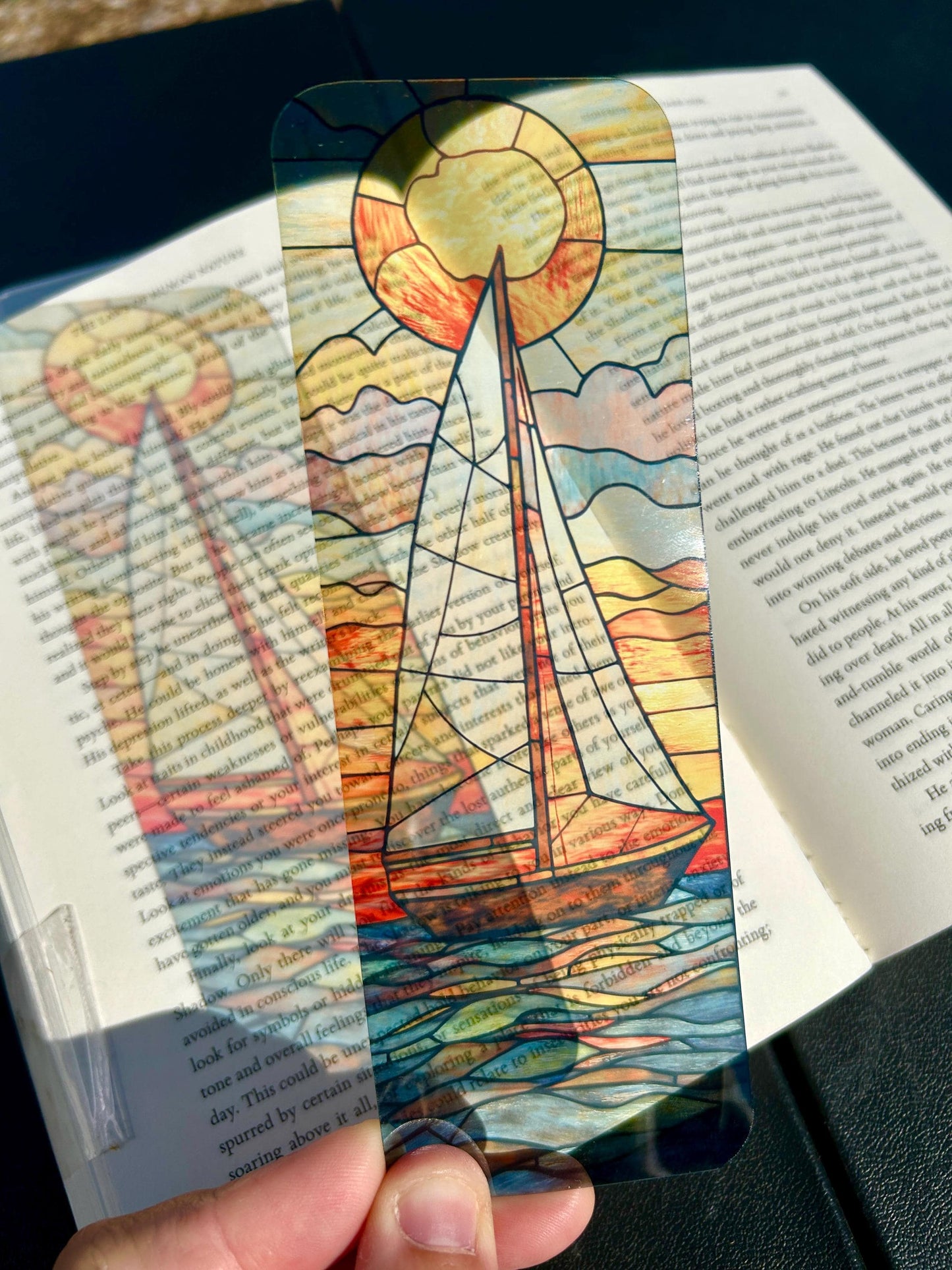 Sailboat at golden sunset bookmark in stained glass style, nautical ocean art with glowing orange and blue waves