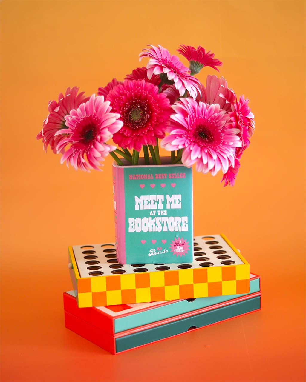 green and pink book ceramic vase: meet me at the bookstore by ban.do with pink flowers inside