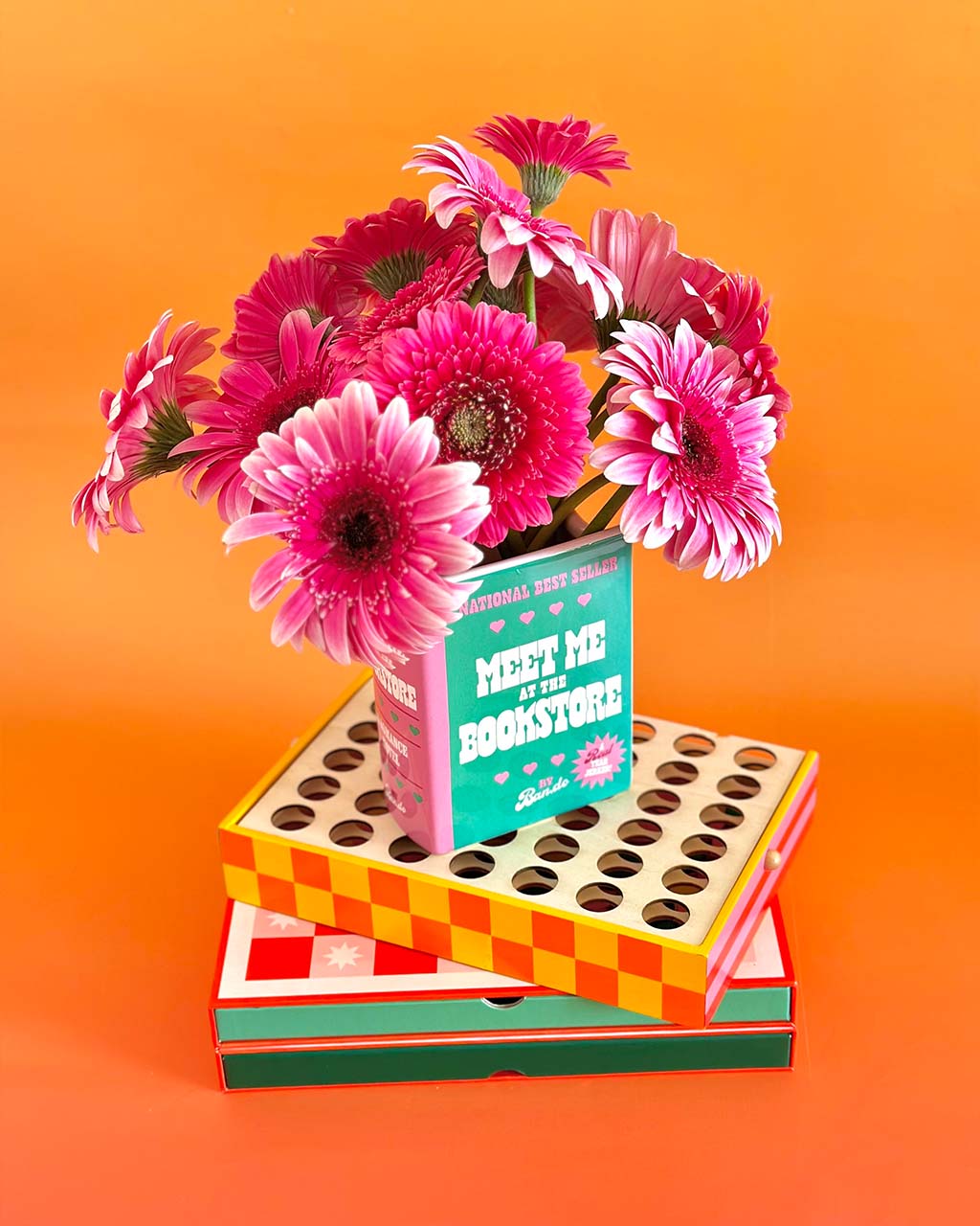 green and pink book ceramic vase: meet me at the bookstore by ban.do with pink flowers inside