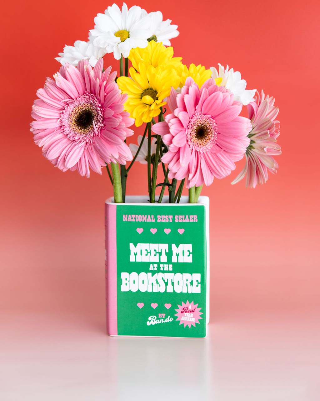 green and pink book ceramic vase: meet me at the bookstore by ban.do with pink flowers inside