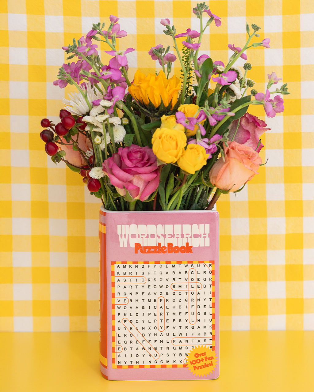 pink word search puzzle book shaped ceramic vase on a yellow gingham background
