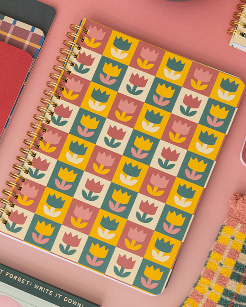 pink, yellow, teal and cream checkered mini notebook with colorful tulip back cover on a pink background
