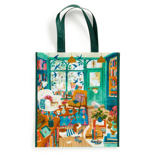 The Bookshop Afternoon Reusable Shopping Bag by Victoria Ball features a vibrant, eco-friendly design of a cozy room with bookshelves, plants, and a cat. This sustainable tote is perfect for book lovers and art fans.